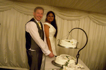 Richard and Sheetal cutting
                                      the cake